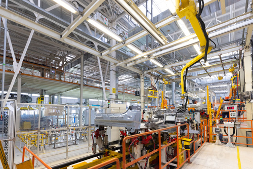 Photo of automobile production line. Welding car body. Modern car assembly plant. Auto industry