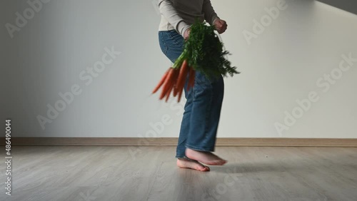 4K of funny and cute teen child girl dancing with freshcarrot at home photo