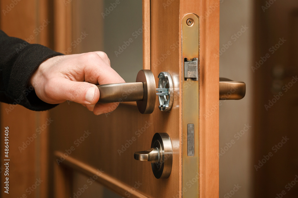 Obraz premium Door Handle Fixing Repairman installs Door Knob Service Handle Door