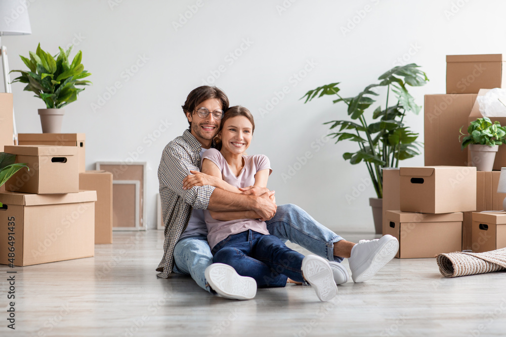 Glad happy caucasian young man in glasses hugs lady among cardboard boxes with stuff in room Glad happy caucasian young man in glasses hugs lady among cardboard boxes with stuff in room