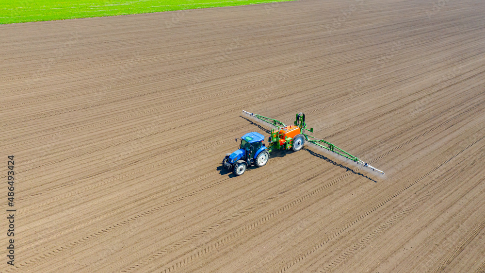 Aerial view on tractor as spraying field with sprayer, herbicide and pesticide Aerial view on tractor as spraying field with sprayer, herbicide and pesticide