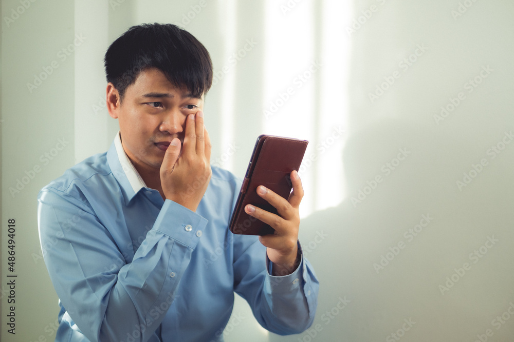 Business man pains his eyes when he watches a mobile phone too much. He presses on his eye by hands. Ophthalmology concept. This shot is medium close up portrait. Natural light on background. Business man pains his eyes when he watches a mobile phone too much. He presses on his eye by hands. Ophthalmology concept. This shot is medium close up portrait. Natural light on background.