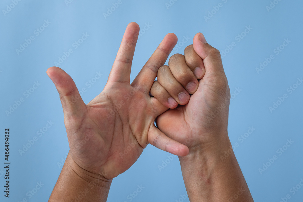 Office syndrome concept. Ring finger is massaged and stretched after working. Close up shot isolate on blue background. Forehand view. Office syndrome concept. Ring finger is massaged and stretched after working. Close up shot isolate on blue background. Forehand view.