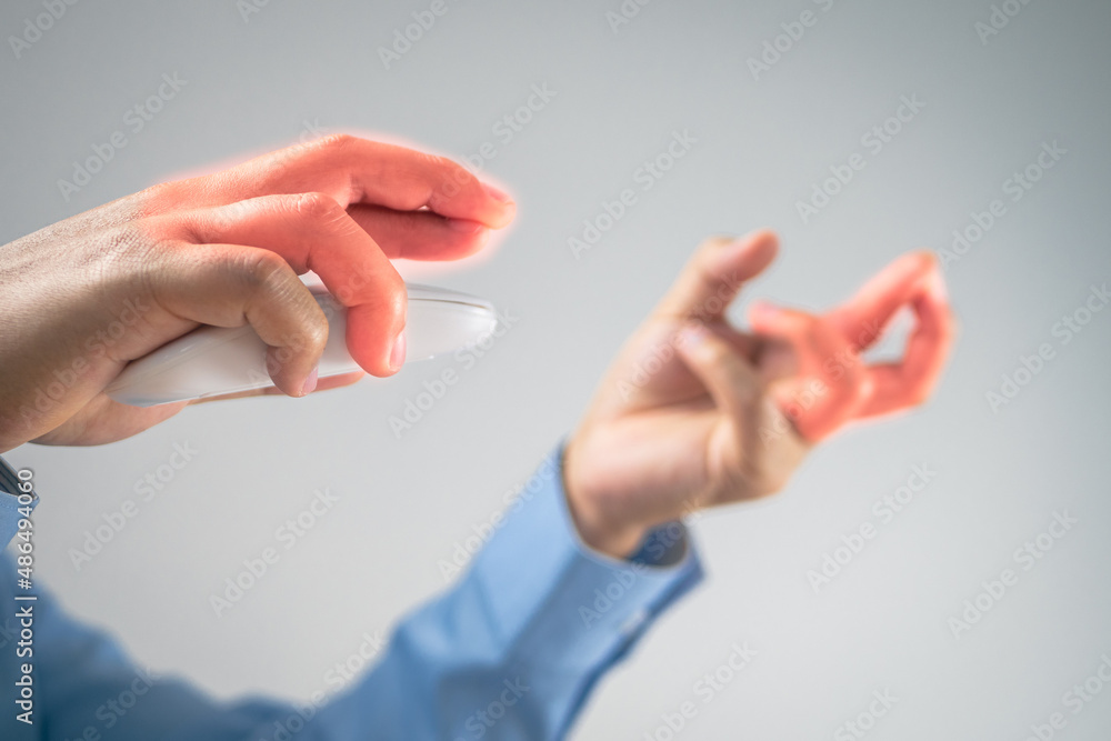 The man uses a mouse until his fingers pain. Office syndrome concept. Pain symptom area is shown with red color. Medium close up shot with some copy space. The man uses a mouse until his fingers pain. Office syndrome concept. Pain symptom area is shown with red color. Medium close up shot with some copy space.