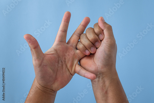 Office syndrome concept. Ring finger is massaged and stretched after working. Close up shot isolate on blue background. Forehand view.