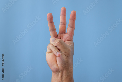 Office syndrome concept. Little finger is stretched after working. Close up shot isolates on blue background. Forehand view. © Dai Yim