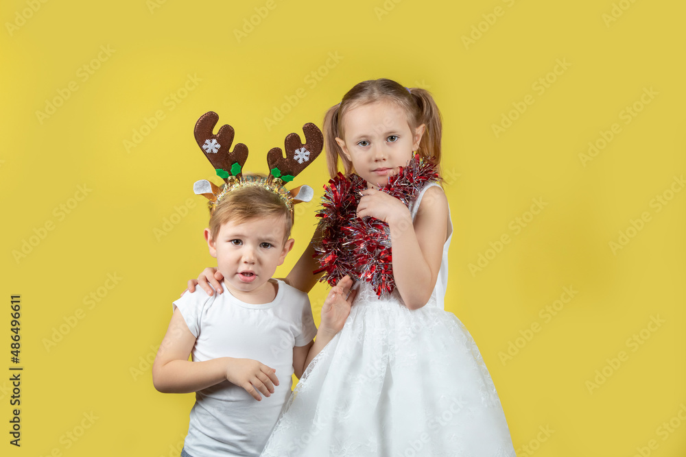 Portrait of children in christmas reindeer costume and dress looking at camera