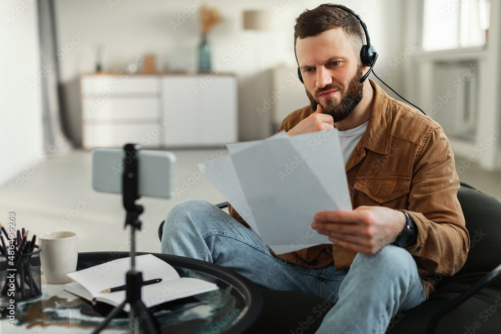 Man Reading Papers Video Calling Via Smartphone At Home Man Reading Papers Video Calling Via Smartphone At Home