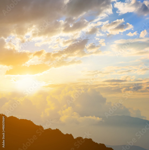mount slope silhouette in dense clouds at the sunset, natural travel background