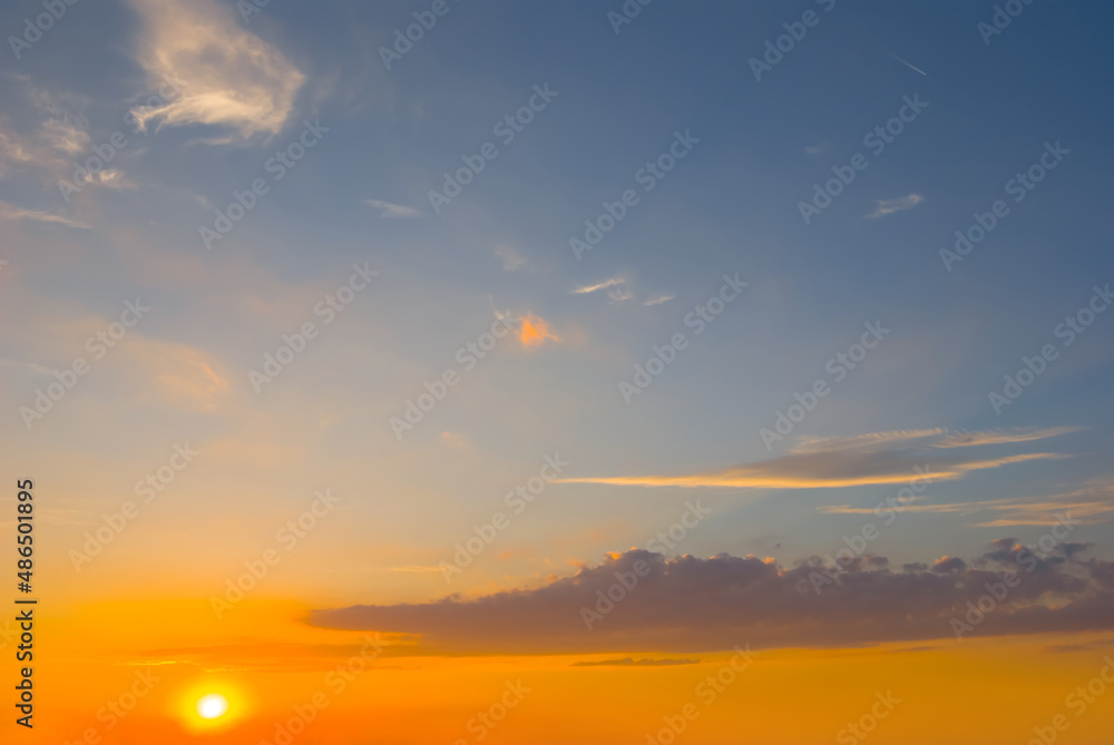 Fototapeta premium dramatic sunset on blue cloudy sky background, natural evening sky scene