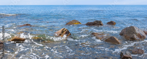 sea coast with stones in water, summer outdoor backround