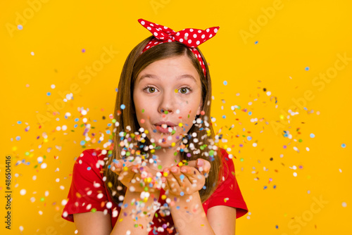 Photo of cute adorable girl send you confetti celebrate holiday event party isolated on yellow color background