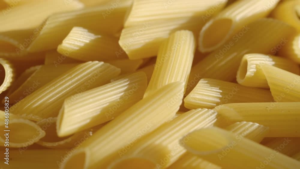 Rotating uncooked pasta . Stack of traditional dry raw macaroni. Nobody Rotating uncooked pasta . Stack of traditional dry raw macaroni. Nobody