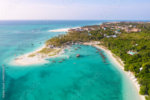 Fototapeta Naklejka Na Ścianę i Meble -  Many boats on the ocean coast and thin strip of sandy beach, palm trees. View from above on the turquoise water. Drone photo 