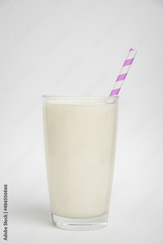glass of milk with purple straw isolated on a white background glass of milk with purple straw isolated on a white background