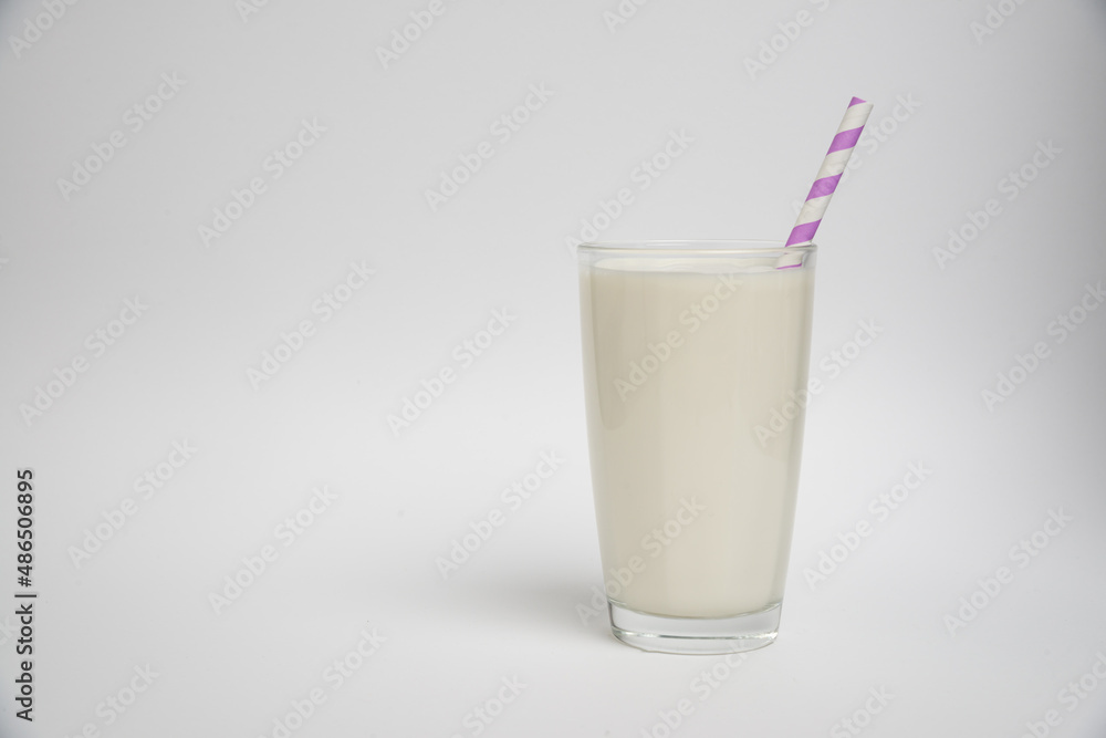 glass of milk with purple straw isolated on a white background