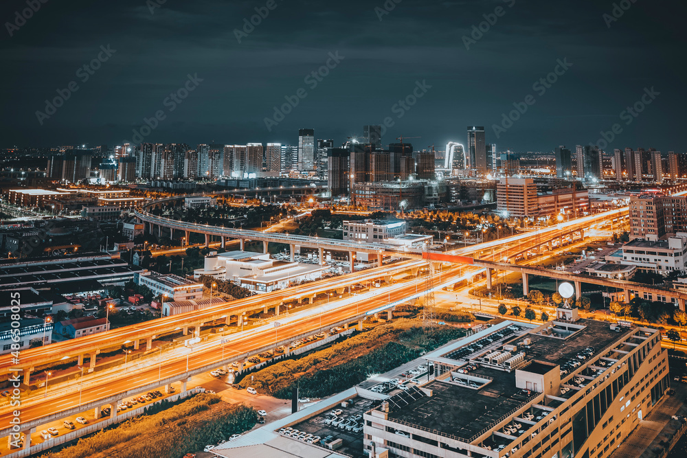 Freeway in night with cars light in modern city.
