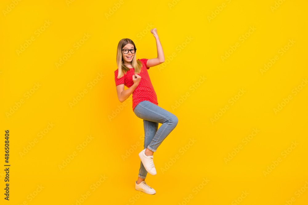 Full size profile side photo of young cheerful lady rejoice success fists hands awesome isolated over yellow color background