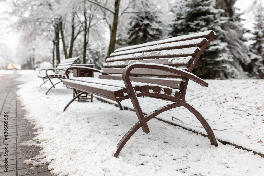 White snow on a park bench.