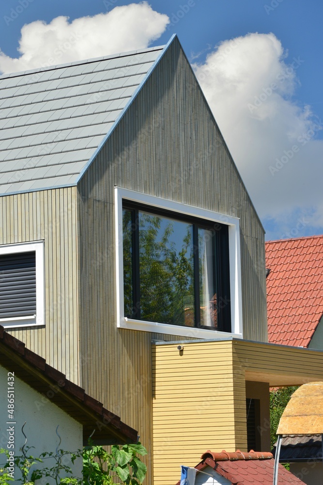 Fassade eines neu renovierten Wohnhauses, verschalt mit lasierten Holzplanken