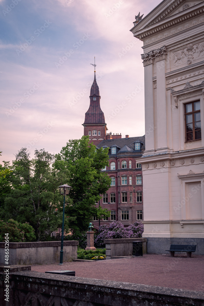 The historic university building and a park during summer sunset in Lund Sweden