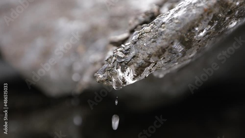 Glacial meltdown in summer. Closeup view of glacier ice cave walls melting into beautiful water drops in slow motion.