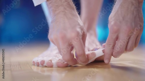 Putting on silicone medical toe corrector against hallux valgus joint strain 4K photo