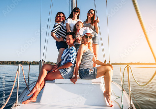 Group of women relaxing on luxury yacht . Having fun together while sailing in the sea. Traveling and yachting concept. © VlaDee
