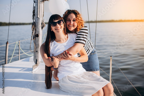 Girlfriends relaxing on the yacht. Two girls celebrating a birthday on the yacht. Evening walk on the yacht on the sea. © VlaDee