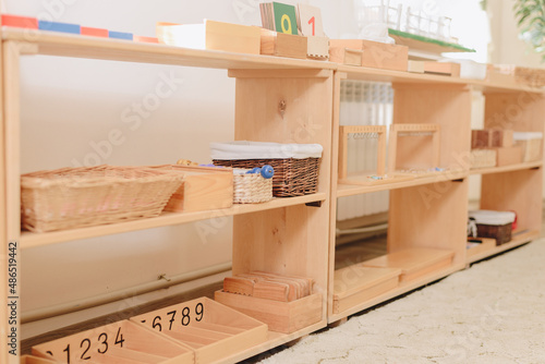 wooden shelf with materials for Montessori studies. study of chickens, mathematics.