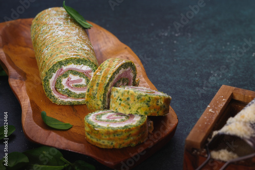 Spinach roulade filled with tomatoes, ham and ricotta for holiday dinner. Selective focus, copy space photo
