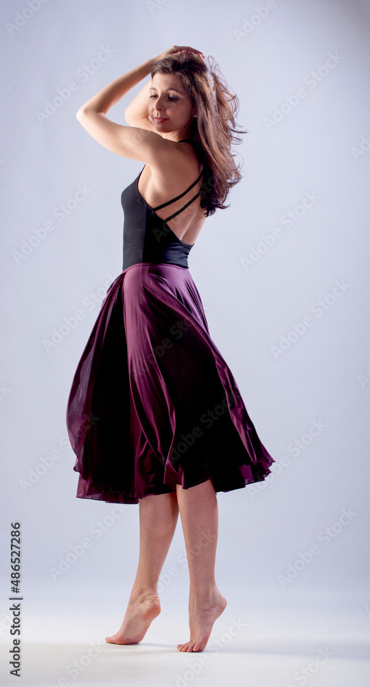 A young woman in a dress is dancing. A young woman in a dress is dancing.
