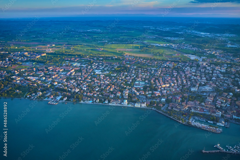 Drone view of Desenzano del Garda. Aerial view. Beautiful Garda Lake with lighthouse (Lago di Garda). View from city of Desenzano del Garda, Italy, on sunny summer day. Natural background.