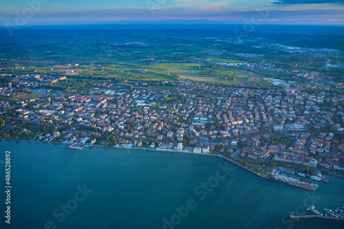 Drone view of Desenzano del Garda. Aerial view. Beautiful Garda Lake with lighthouse (Lago di Garda). View from city of Desenzano del Garda, Italy, on sunny summer day. Natural background. © Berg