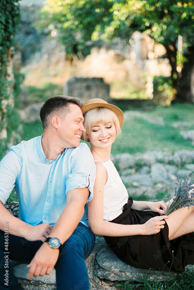 Smiling couple sitting on stone steps in the garden
