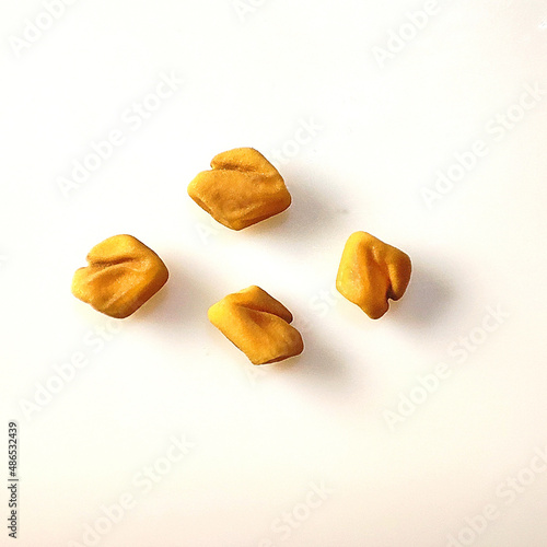 Macro shot of Fenugreek Seeds on white background.