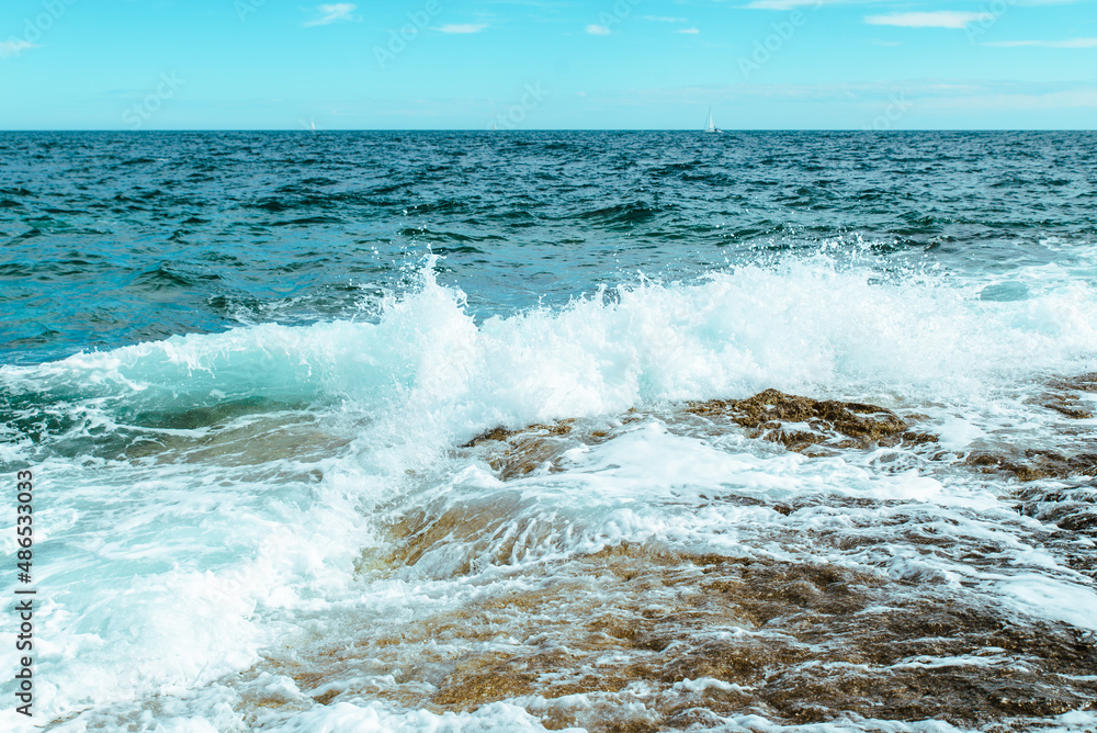 Fototapeta premium view of rocky seaside waves with white foam