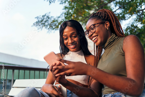 two young women having fun with a mobile phone