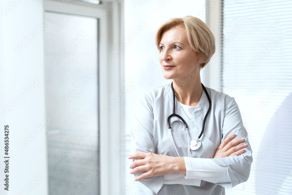 Confident doctor with crossed arms standing in cabinet Confident doctor with crossed arms standing in cabinet