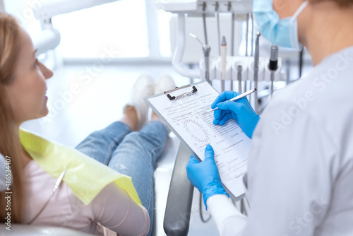Dentist writing results of patient s examination at appointment