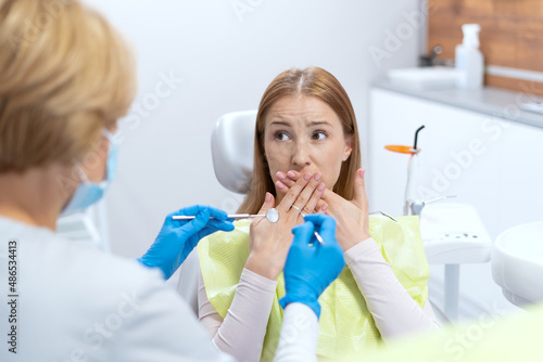Scared patient at dentist appointment in modern clinic