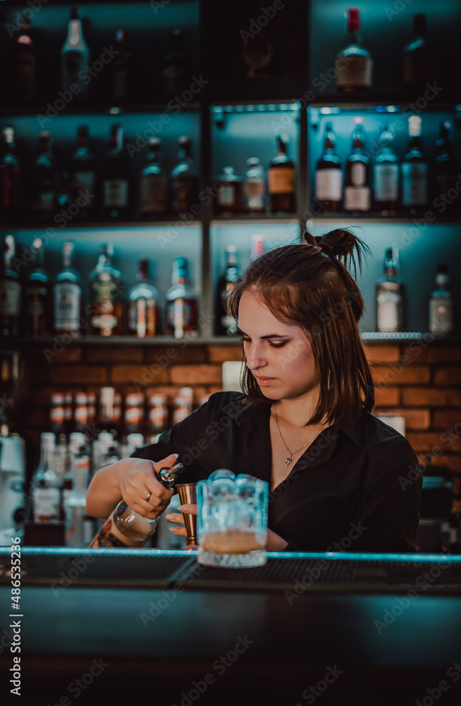 young  woman bartender Making Cocktail in bar
