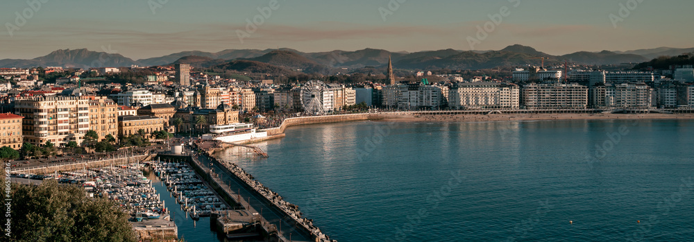 Obraz premium Panoramic view of La Concha Beach at sunset. The port, the town hall, the yacht club and the Ferris wheel.