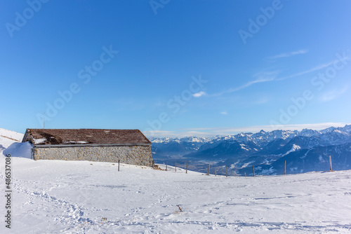 Isolated summer chalet and farm stables high up on the Swiss Alps covered in fresh powder snow near the Kamor peak in Appenzell photo