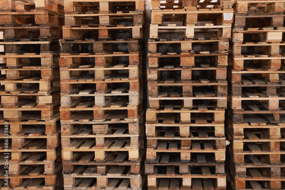 Many empty wooden pallets stacked as background