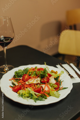 Girl is tasting alcoholic beverage and cheese. Traditional restaurant plate of food and wine