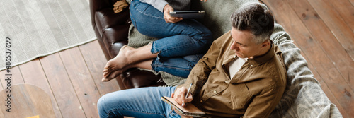 Smiling middle aged white couple relaxing on a couch