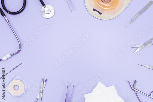 Foto Surgeon's set: colostomy bag, surgical instruments, stethosco and bandages on a light lilac