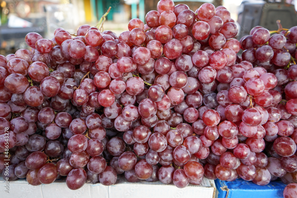 Sweet red grapes are sold in roadside fruit shops in Indonesia. This fruit is imported from abroad. This fruit has small seeds in it which when chewed are very bitter in taste.