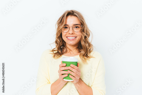 Smiling woman holding paper cup of coffee